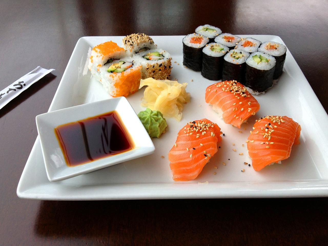 Plato con diferentes sabores de sushis con salsa wasabi donde al lado del plato aparecen los palillos para coger el sushi