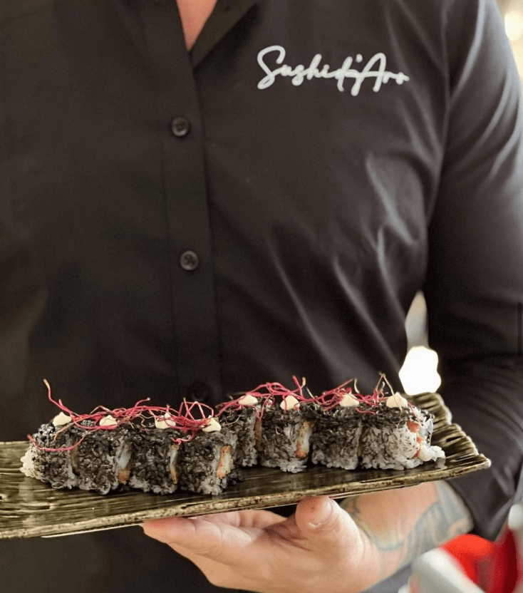 Trabajador de Sushi D'aro sosteniendo el plato con los sushis que hay para llevarlos a la mesa