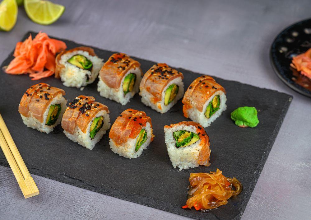 Sushi en una tabla cortado para llevar a la mesa junto con los palillos para ayudar a coger el sushi